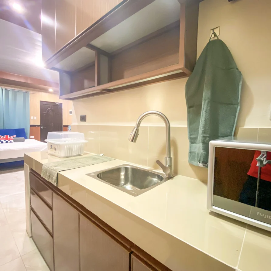 Deluxe Studio Room with queen bed, bunk bed, Smart TV, and kitchenette at Vera Cruz Apartelle in Tagbilaran City, Bohol