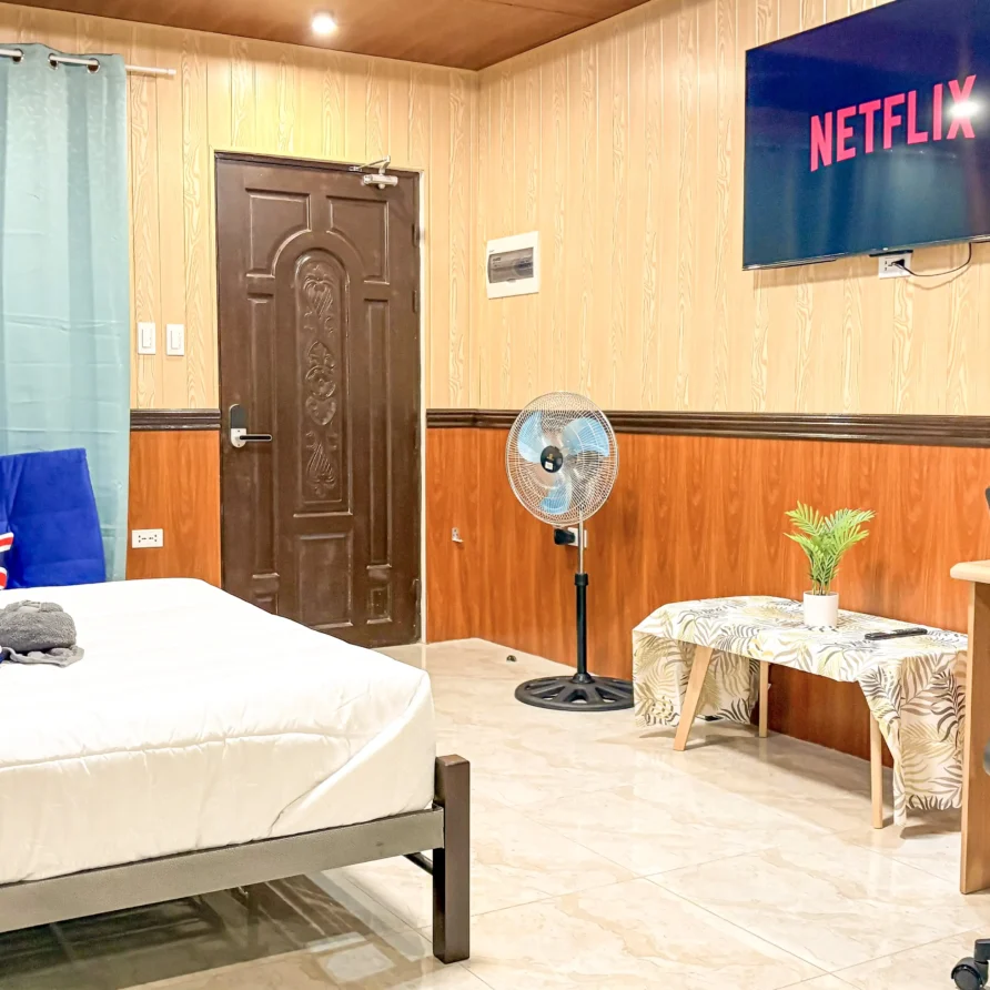 Deluxe Studio Room with queen bed, bunk bed, Smart TV, and kitchenette at Vera Cruz Apartelle in Tagbilaran City, Bohol