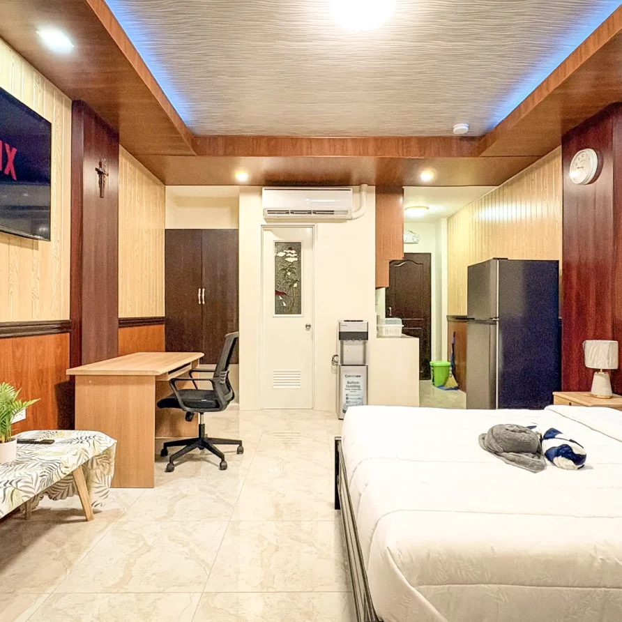 Deluxe Studio Room with queen bed, bunk bed, Smart TV, and kitchenette at Vera Cruz Apartelle in Tagbilaran City, Bohol