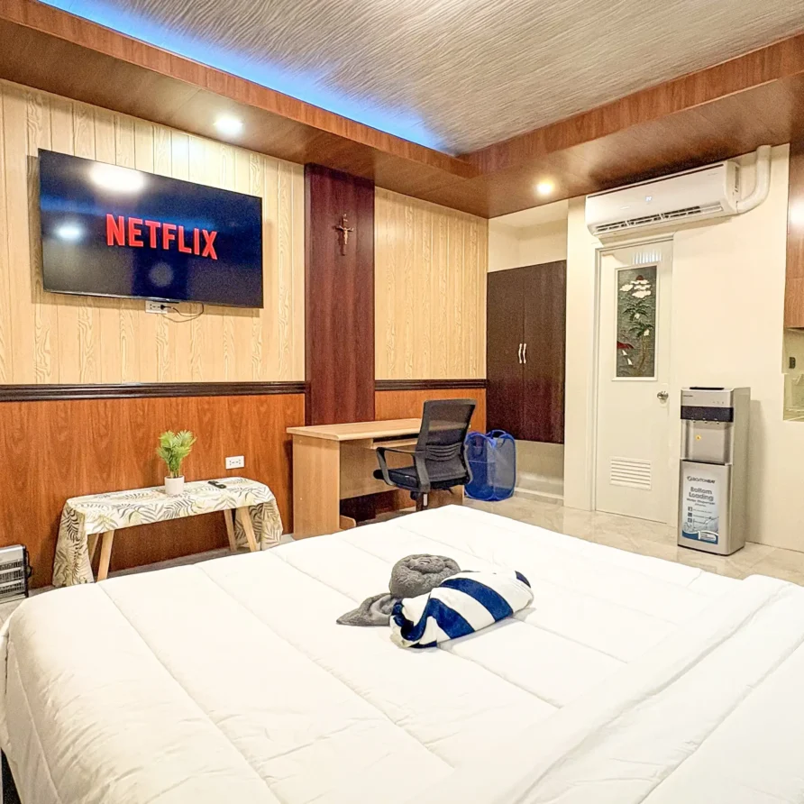 Deluxe Studio Room with queen bed, bunk bed, Smart TV, and kitchenette at Vera Cruz Apartelle in Tagbilaran City, Bohol