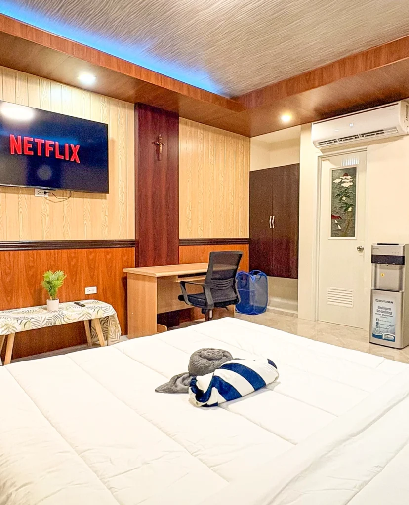 Deluxe Studio Room with queen bed, bunk bed, Smart TV, and kitchenette at Vera Cruz Apartelle in Tagbilaran City, Bohol