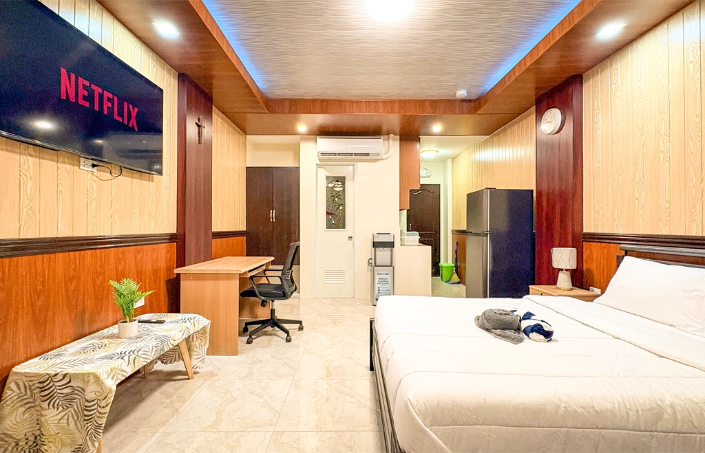Deluxe Studio Room with queen bed, bunk bed, Smart TV, and kitchenette at Vera Cruz Apartelle in Tagbilaran City, Bohol